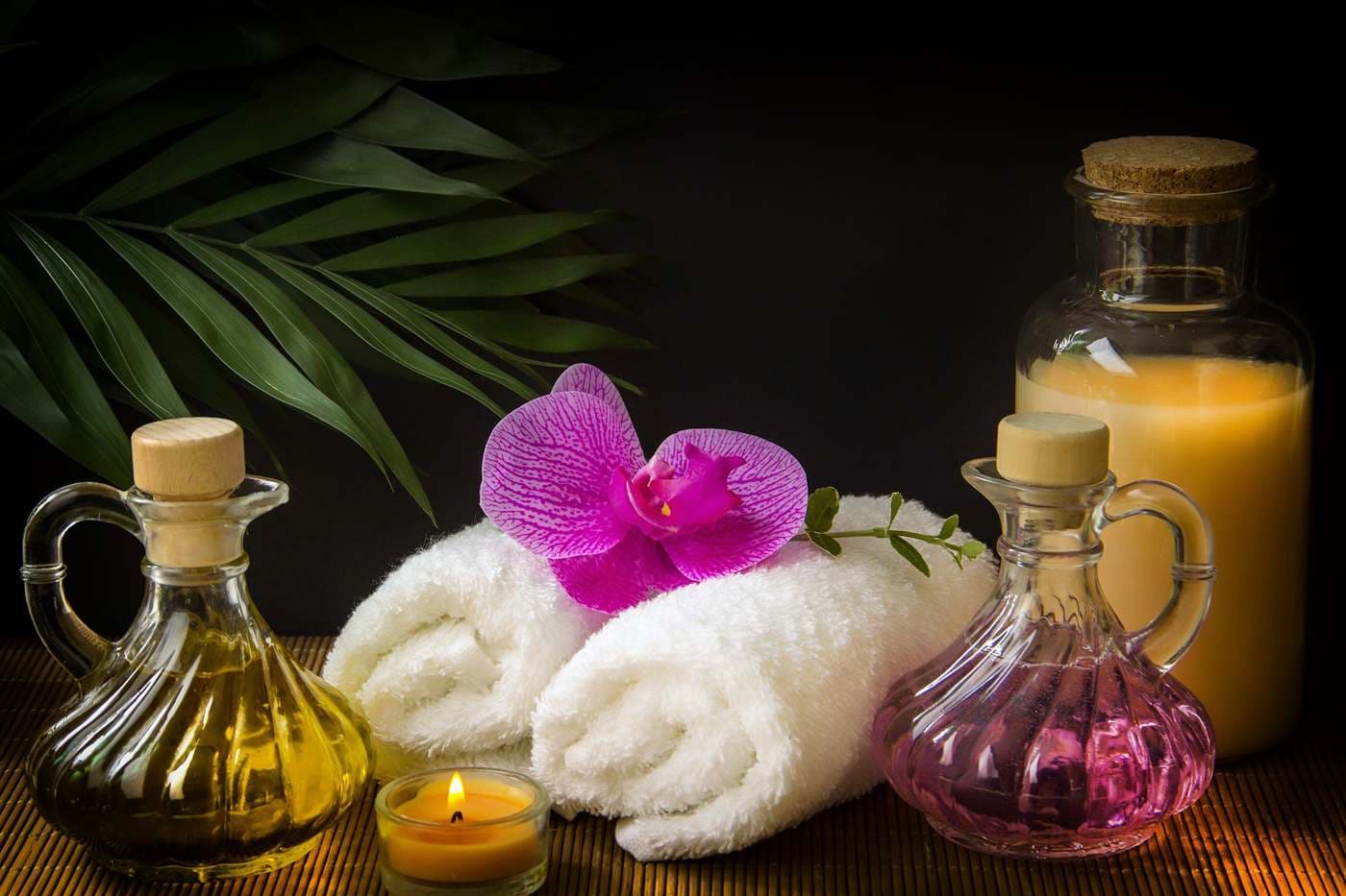 Masážne oleje, sviečky, uteráky a orchidea v pokojnom prostredí